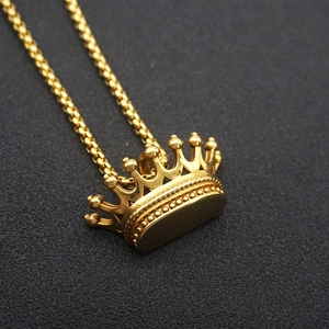 Detailed close-up of golden crown pendant with bead textures on a black background