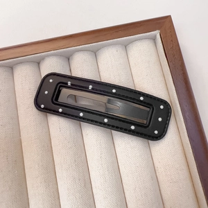 Detail einer Vintage PU-Leder Haarspange mit weißen Punkten und feiner Kantennaht