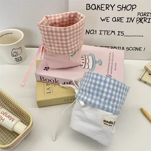 Detailed view of pink and blue checkered canvas drawstring storage bags for stationery