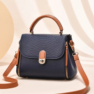 Elegant navy blue crocodile embossed handbag with brown leather straps and gold hardware