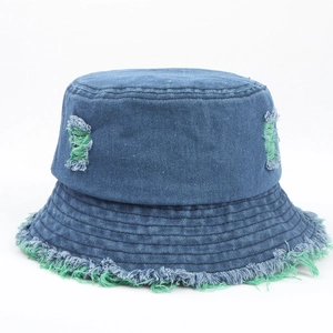Dettaglio cappello pescatore in denim con strappi e bordi sfrangiati verde acceso