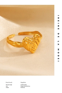 Detailed view of golden heart ring with hand-chiseled texture and adjustable open band