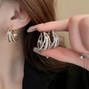 Close-up of geometric layered hoop earrings with emerald cut cubic zirconia stones