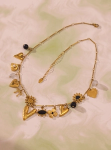 Close-up of gold stainless steel necklace with heart, enamel flower and pearl charms