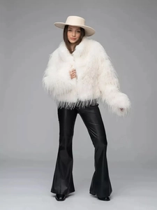Full view of thick white faux fur jacket with wide-leg trousers and elegant hat