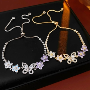 Details von Zirkonia Schmetterling und Blumen Anhängern an verstellbaren Armbändern