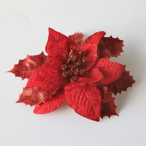 Red artificial poinsettia Christmas flower with glitter finish on a white background