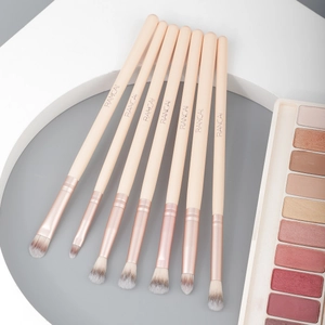 7-piece synthetic eye makeup brush set with rose gold ferrules on geometric pedestals