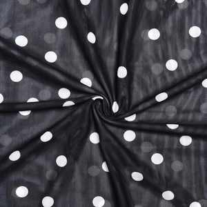 Detail of black polka dot mesh fabric showing elegant pleated texture and soft drape