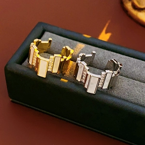Detail of geometric rings with gold plating and white inlay in a luxury jewelry box