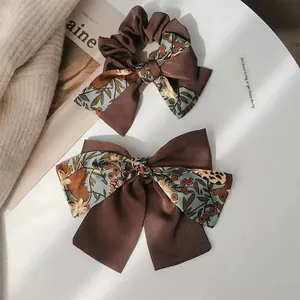Retro bow hair scrunchie and clip set in dark brown floral print on white desk