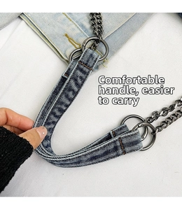 Detail of light blue washed denim bag strap with dark gunmetal rings and chunky metal chain