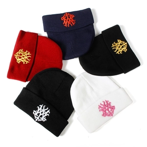 Mise à plat de plusieurs bonnets en maille avec logos brodés de style gothique