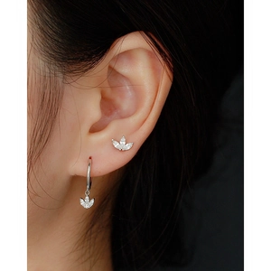 Macro shot of 925 silver flower earrings with sparkling zircons worn by a model