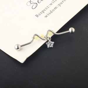 Macro view of wave-shaped industrial barbell with silver star pendant and yellow beads
