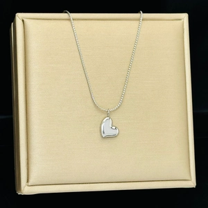 Polished silver heart pendant necklace on luxury silk texture jewelry display