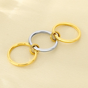 Detail of linked gold and silver layered rings on champagne silk textured background