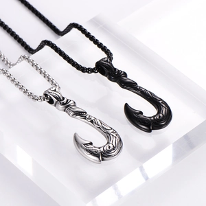 Silver and black fish hook pendants with intricate tribal engravings on metal chains