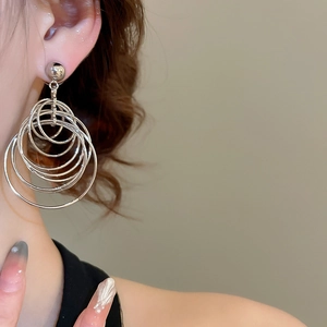 Detail of silver multi-layered hoop earrings showing unique interlocking metal rings