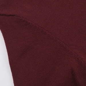 Detalle del tejido de punto y costuras del vestido burdeos con mangas largas