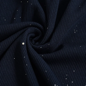 Makro-Detail von dunkelblauem Strickstoff mit eleganten Goldpailletten und Rippenmuster