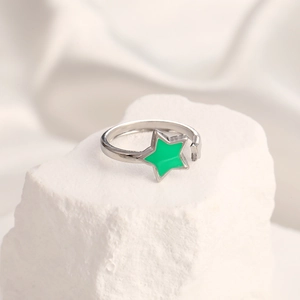 Macro detail of adjustable silver ring featuring a vibrant green enamel star charm