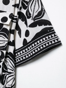 Detail of sleeve cuff and side pocket with geometric ethnic print on linen fabric
