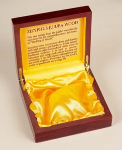 Macro shot of an open vintage wooden gift box with yellow satin lining and inner text