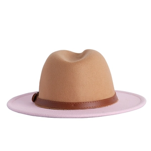 Detail of two-tone felt fedora hat featuring a tan crown and pink brim with leather band