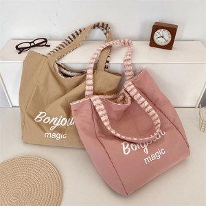 Dual-color canvas tote bags with plush striped handles and Bonjour Magic text prints
