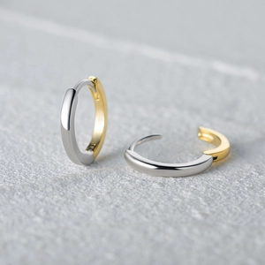 Close-up of S925 sterling silver two-tone curved wave earrings with hallmark detail