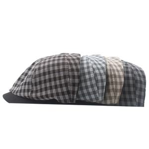 Detail of four retro plaid newsboy hats in various colors with breathable fabric texture