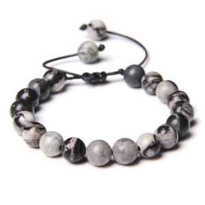 Detailed view of handmade woven tiger eye stone bracelet with adjustable black wax cord