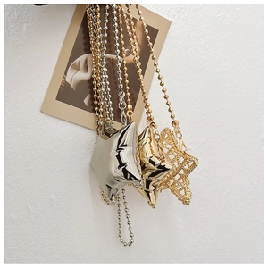 Close-up of polished silver and gold star pendants on delicate bead chains with decor