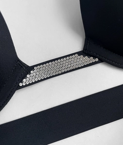 Macro shot of silver rhinestone strap on backless black bra with smooth high-stretch fabric