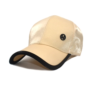Detail of champagne satin baseball cap showing side M logo and black piped brim