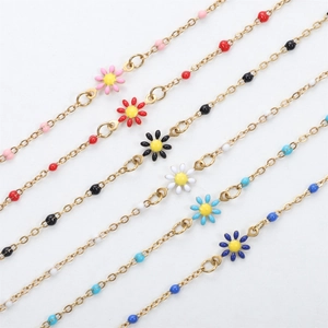 Golden daisy link bracelets with colorful enamel charms and beads in various colors