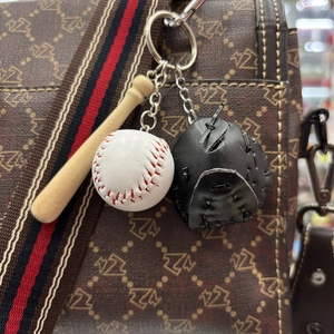 Detailed view of mini wooden baseball bat, white ball, and black leather glove keychain