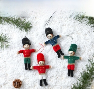 Detailed view of four walnut soldier fabric pendants with gold embroidery on snow background