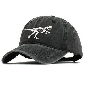 Detailed close-up of white dinosaur skeleton embroidery on washed cotton baseball cap