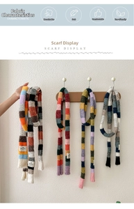 Close-up of colorful striped knit scarf showing soft texture and logo detail