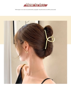 Détail d'une élégante pince à cheveux en métal doré dans un chignon à la française