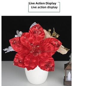 Detail of red velvet poinsettia with glitter petals and gold leaves in ceramic vase