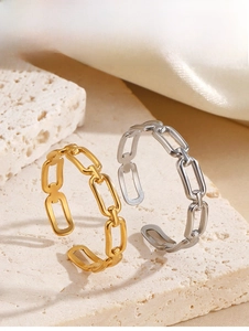 Macro view of gold and silver square chain rings on stone for minimalist style