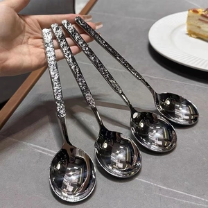 Macro view of four silver stainless steel spoons featuring textured hammered finish handles