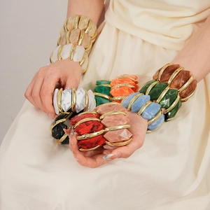Détail d'un bracelet géométrique coloré en acrylique avec accents dorés
