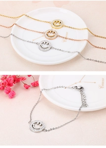 Nahaufnahme von minimalistischen Smileys mit Diamanten auf dreifarbigen Kettenarmbändern