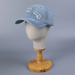 Berretto da baseball in denim azzurro con toppe sfrangiate e ricami decorativi