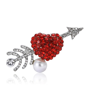 Elegant silver arrow and red crystal heart brooch with a pearl accent on white surface