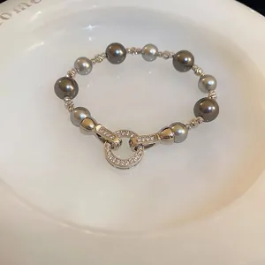 Armband mit unregelmäßigen Perlen, Zirkonia-Rundverschluss auf weißem Keramiktablett
